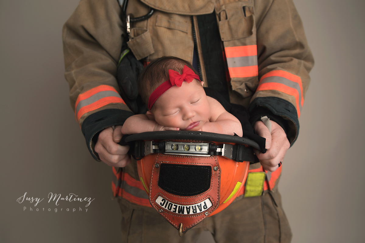 baby girl sleeping in firehat by Las Vegas newborn photographer Susy Martinez Photography