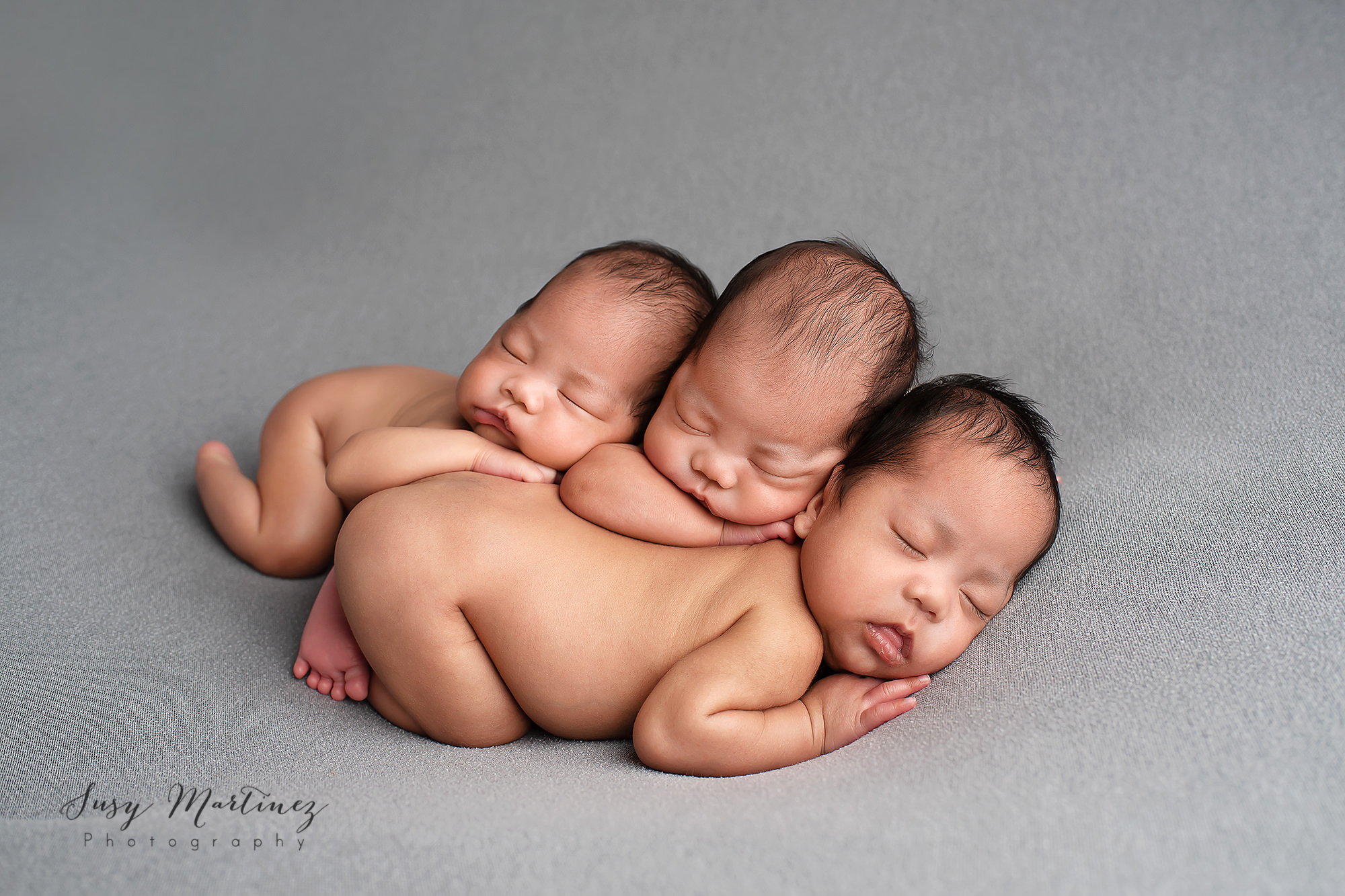 babies lay together during newborn session with triplets