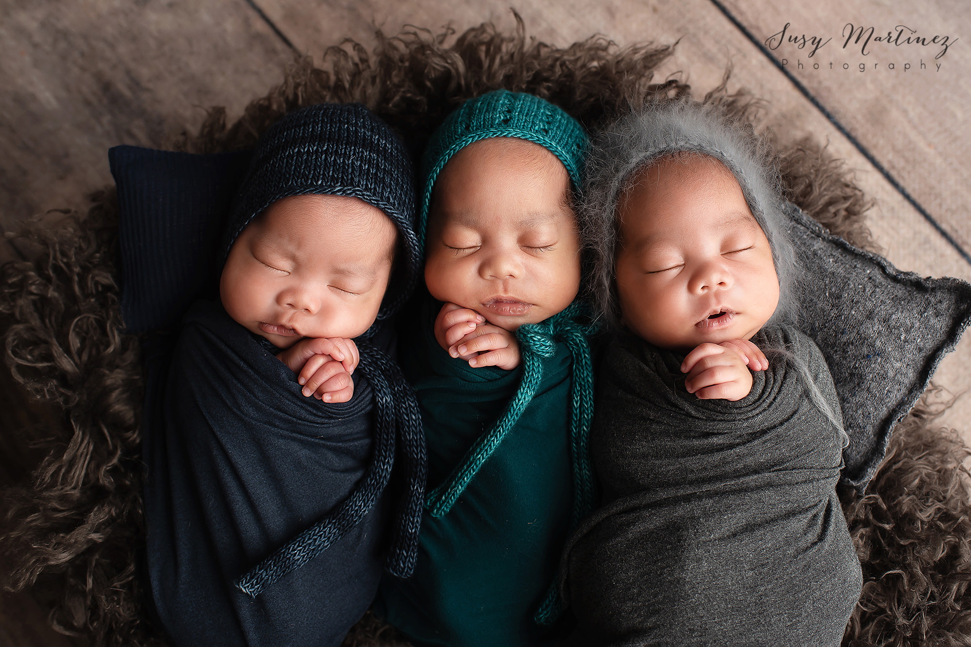 three babies wrapped in dark neutral colors for newborn portraits in Henderson NV