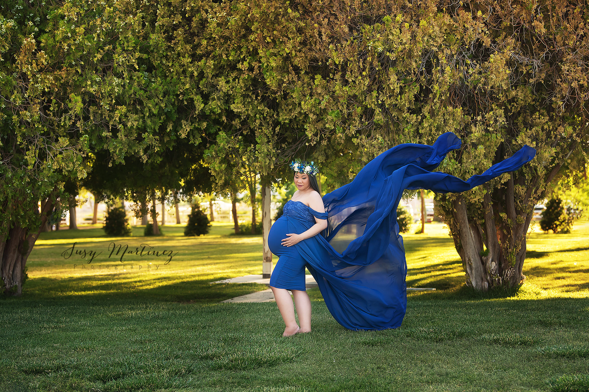 mom pregnant with triplets poses in navy blue Sew Trendy Accessories gown