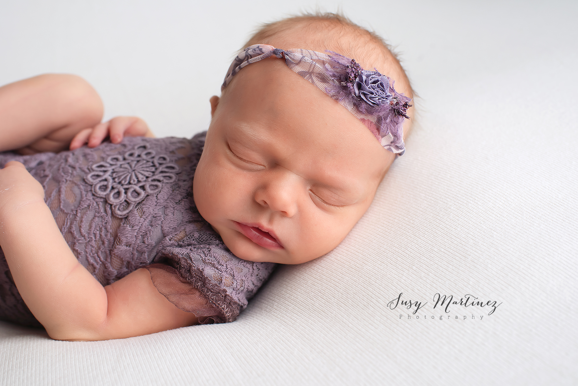Henderson Newborn Photographer photographs baby girl with purple headband
