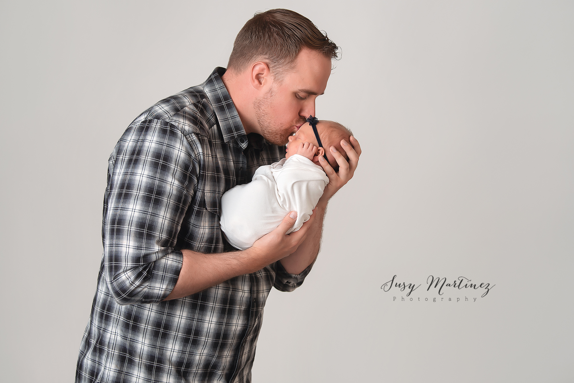dad kisses newborn baby girl during Las Vegas newborn photoshoot