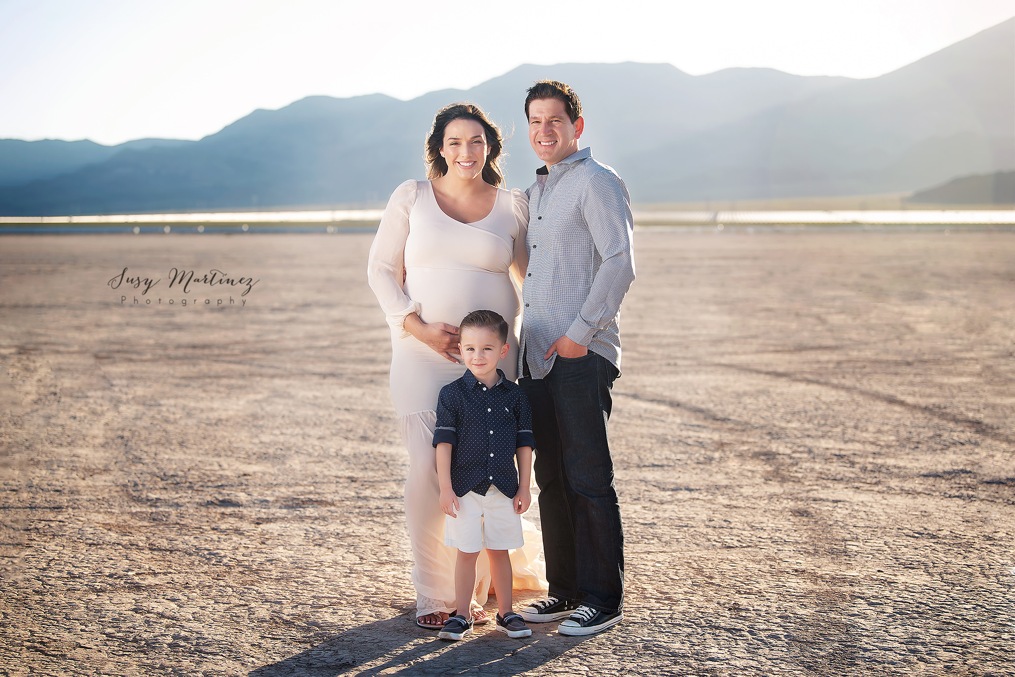 family of three poses during Dry Lake Bed maternity session in Las Vegas