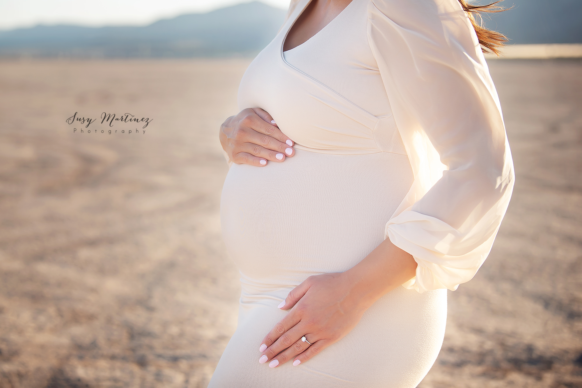 mom holds belly during maternity session in Las Vegas