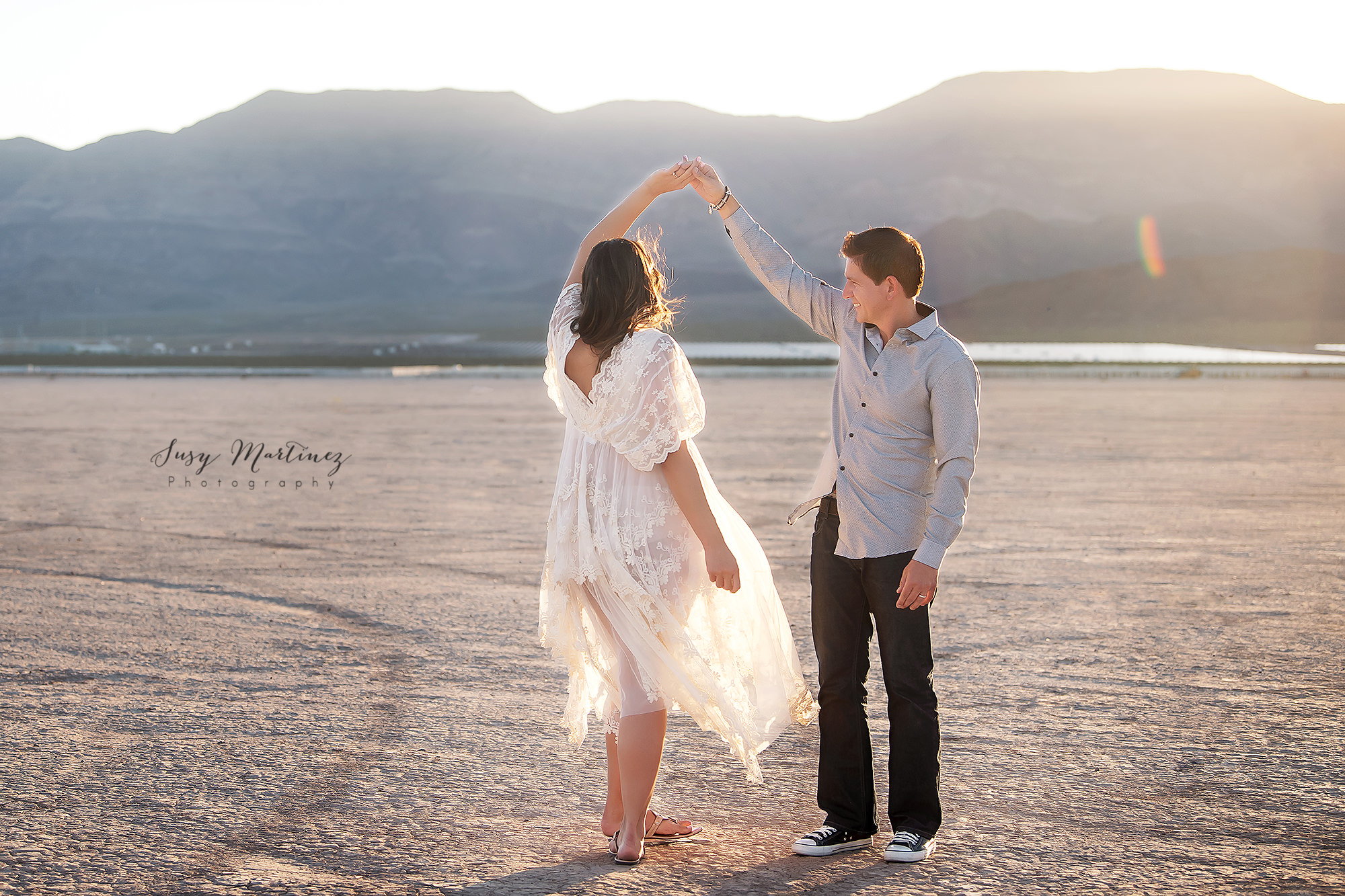 husband twirls wife during maternity session in Las Vegas