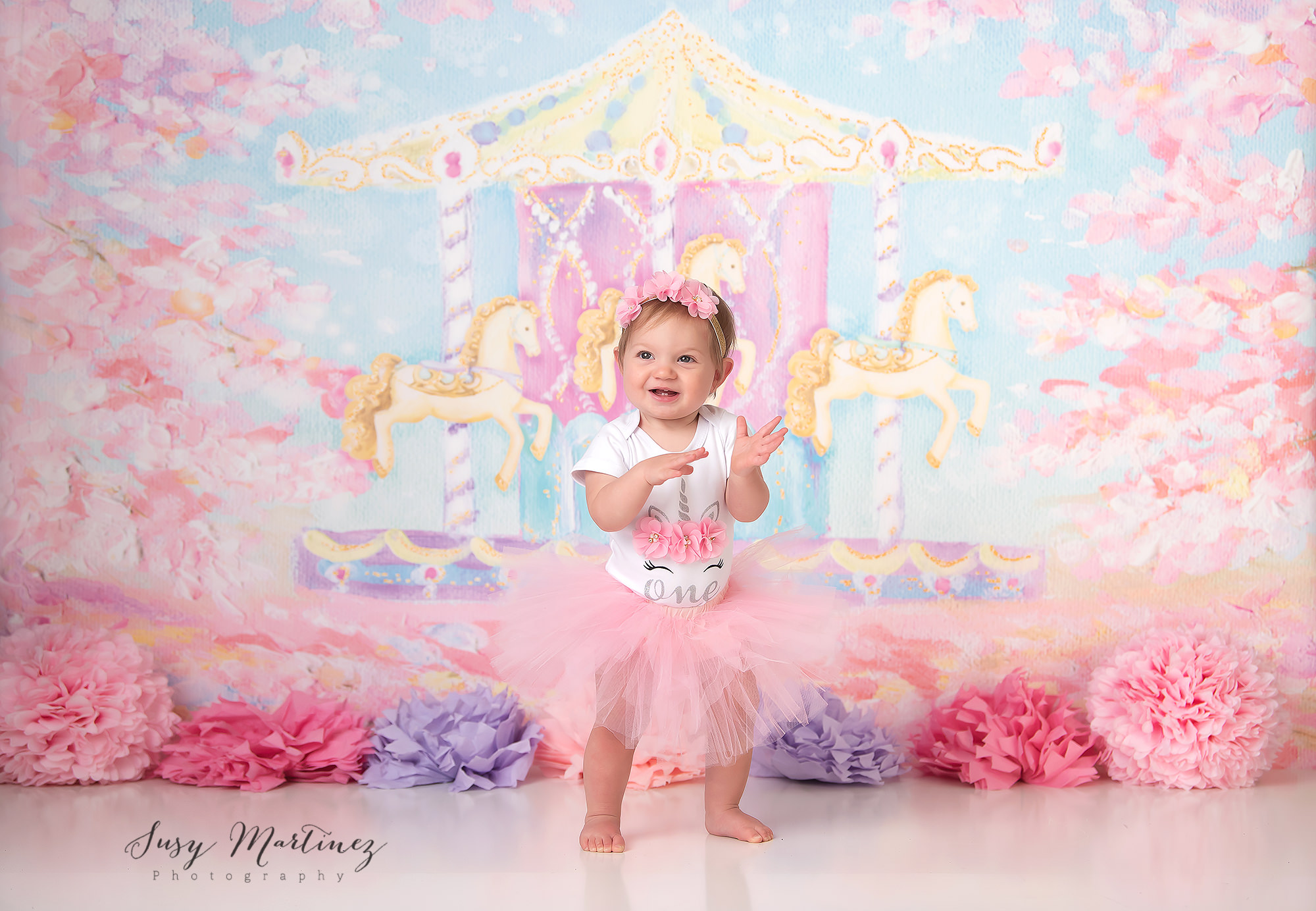 baby girl smiles during milestone portraits for first birthday