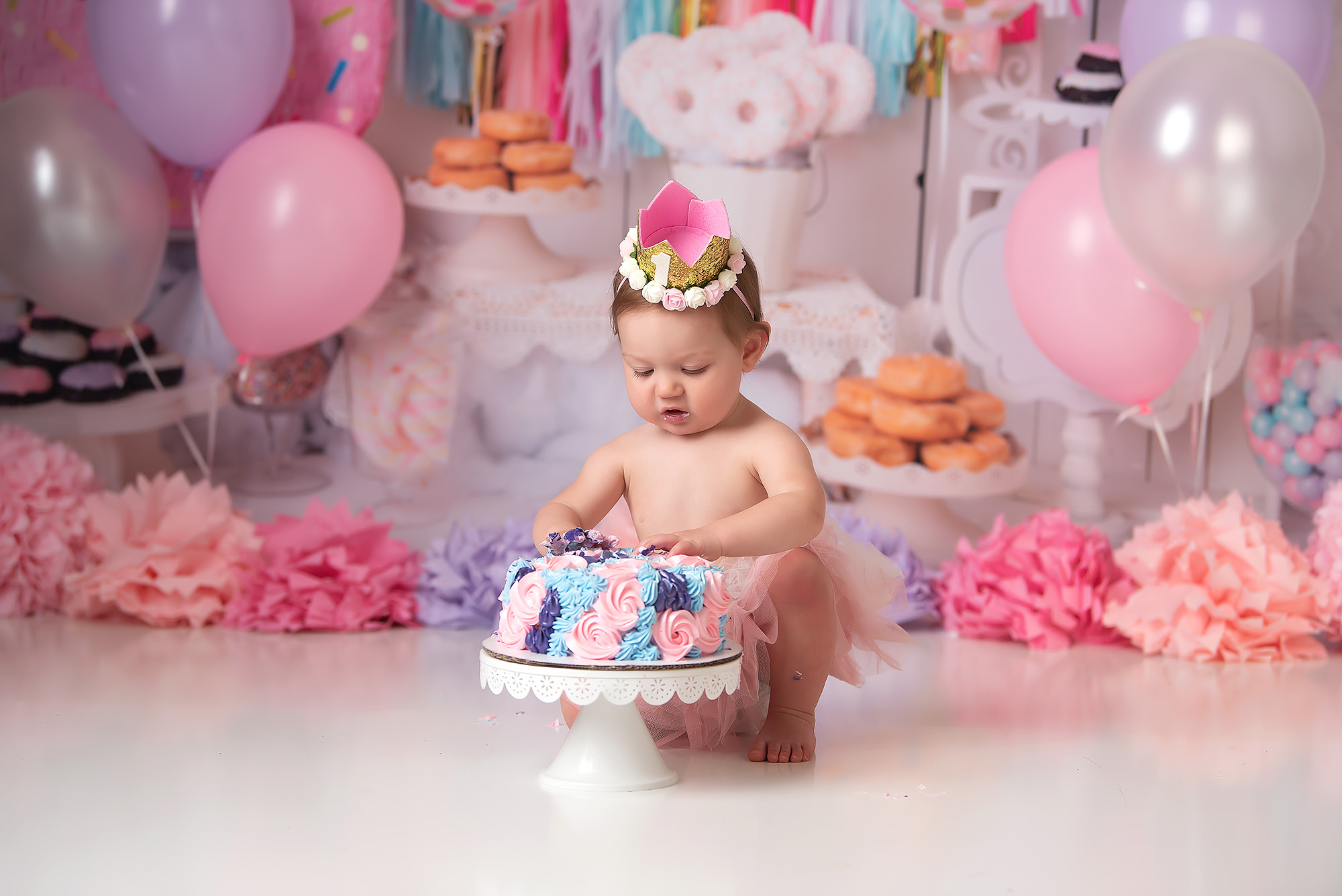 baby girl plays with cake during pastel cake smash