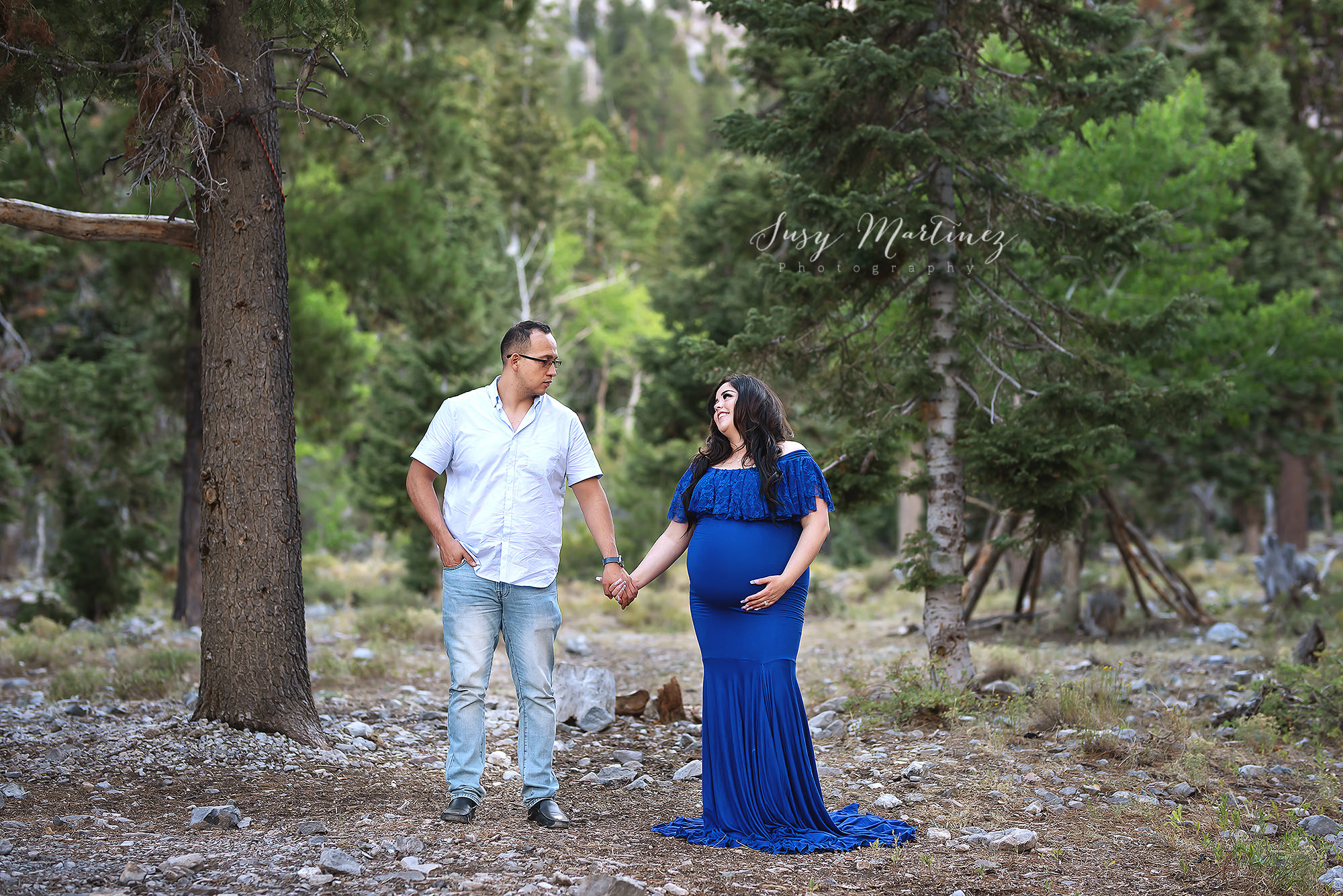 parents to be hold hands during mountain maternity portraits