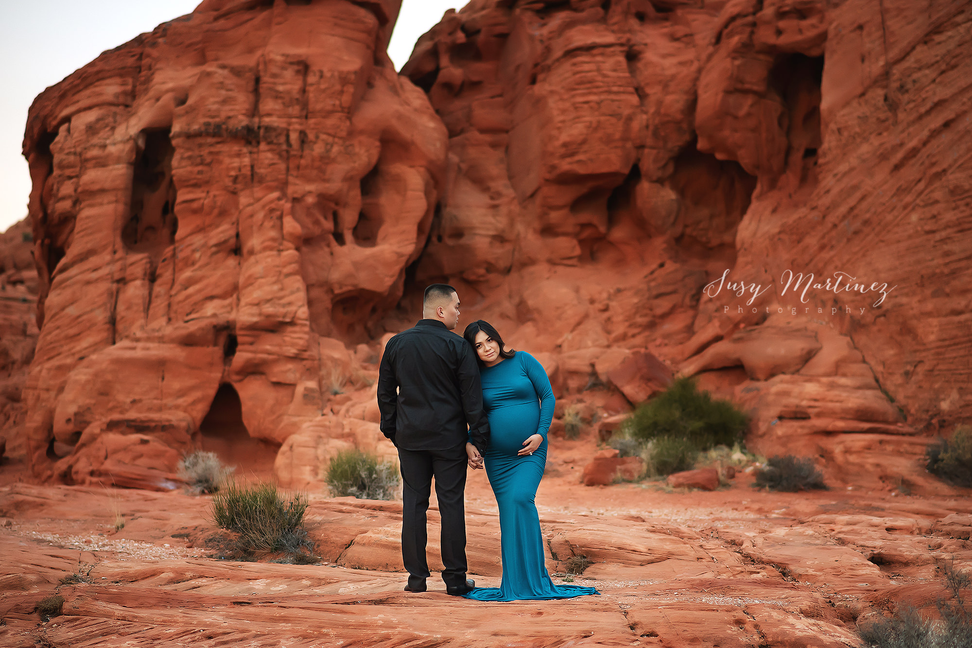 mom leans against dad holding belly in Valley of Fire