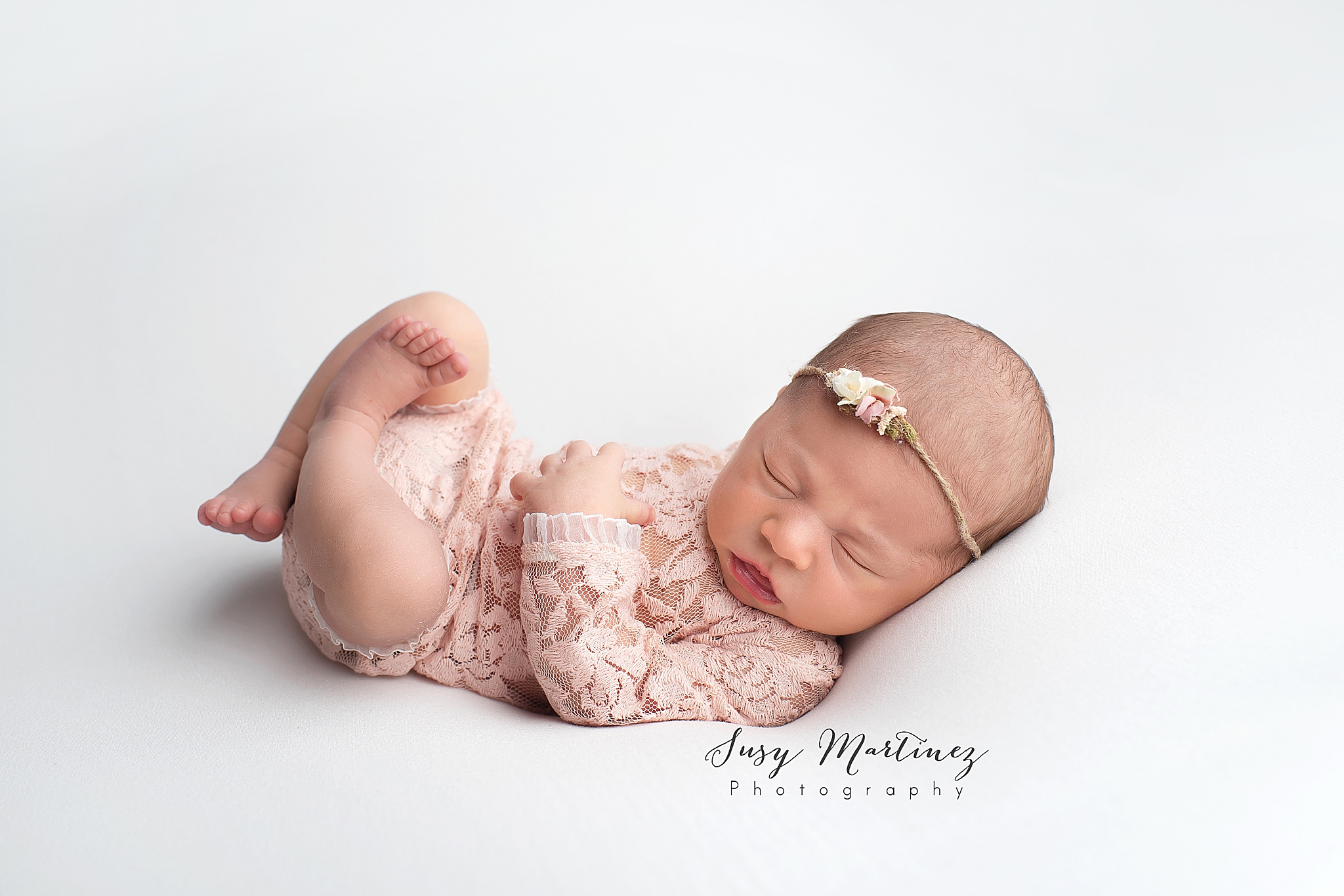 baby in boho inspired lace onesie sleeps during studio newborn portraits