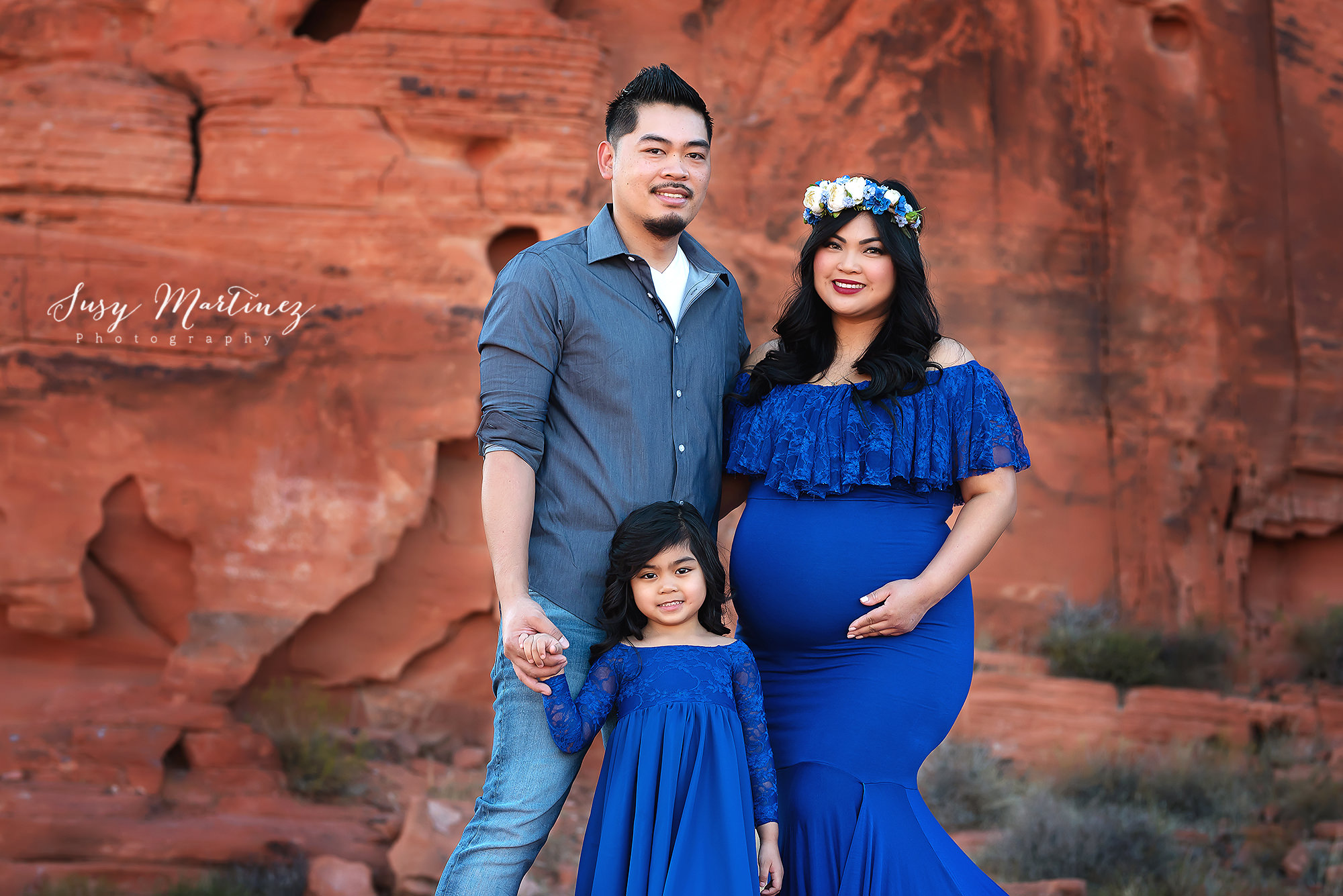 family of three poses in Valley of Fire during maternity photos