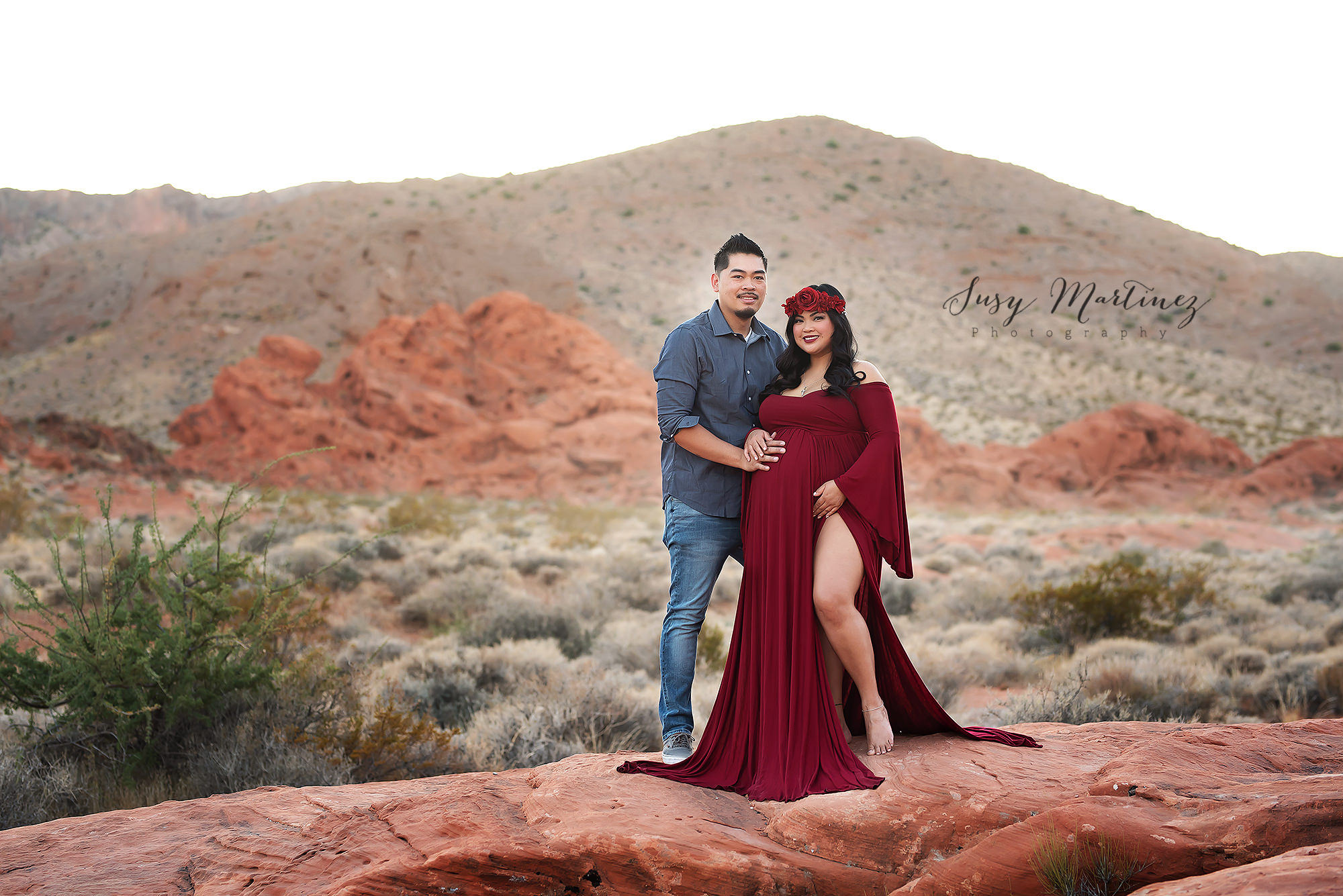 husband and wife pose on red rocks in Valley of Fire Maternity Session