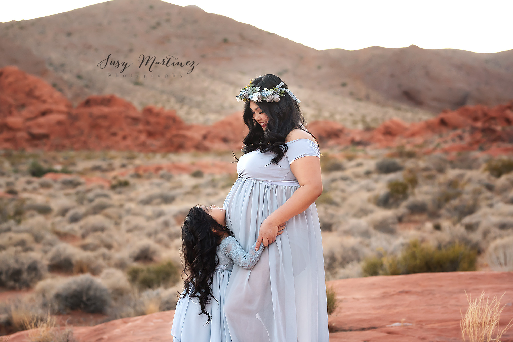 mom looks at daughter over belly during maternity portraits in Las Vegas