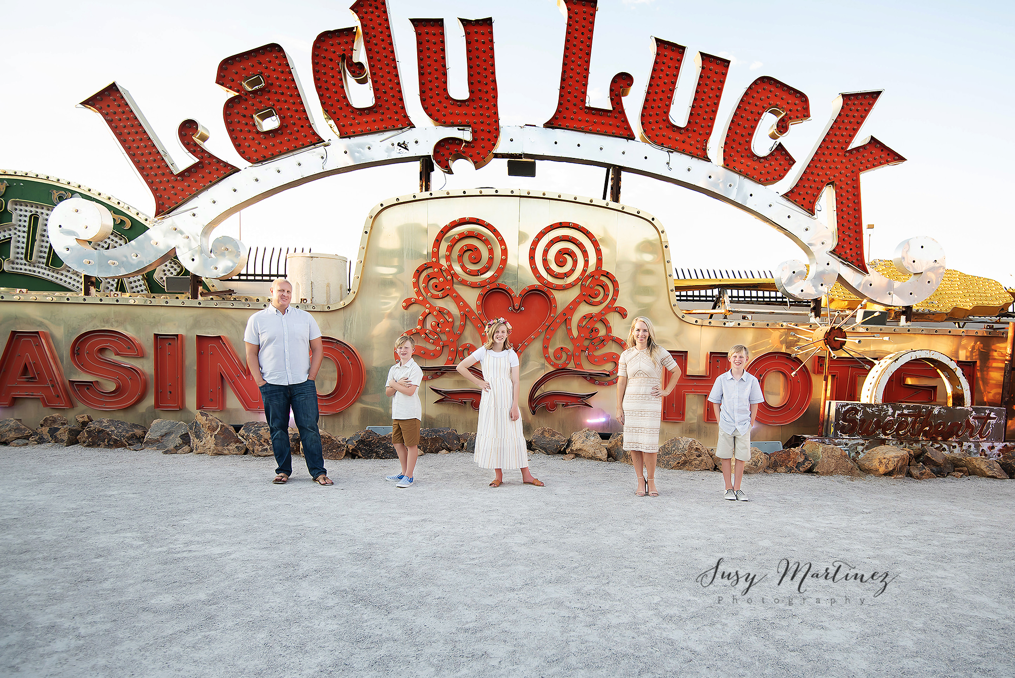 family of five poses under Lady Luck sign in Neon Boneyard