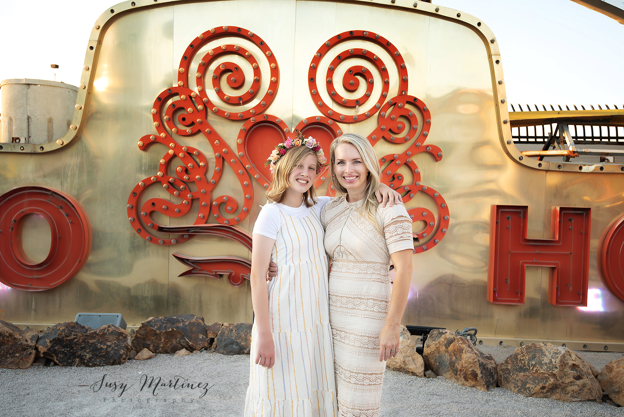 mom and daughter pose in front of gold sign during Neon Boneyard Family Portraits