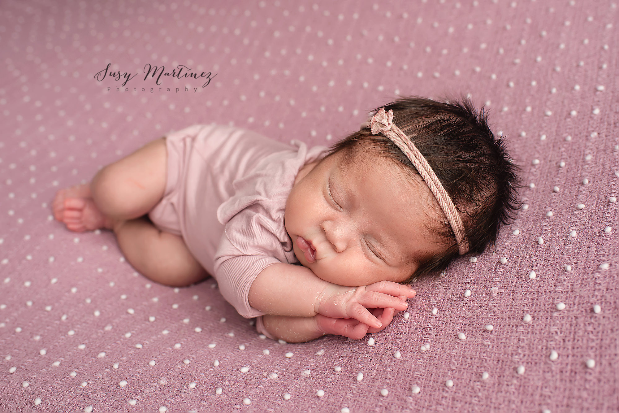 newborn baby girl sleeps with hands under her head in Las Vegas