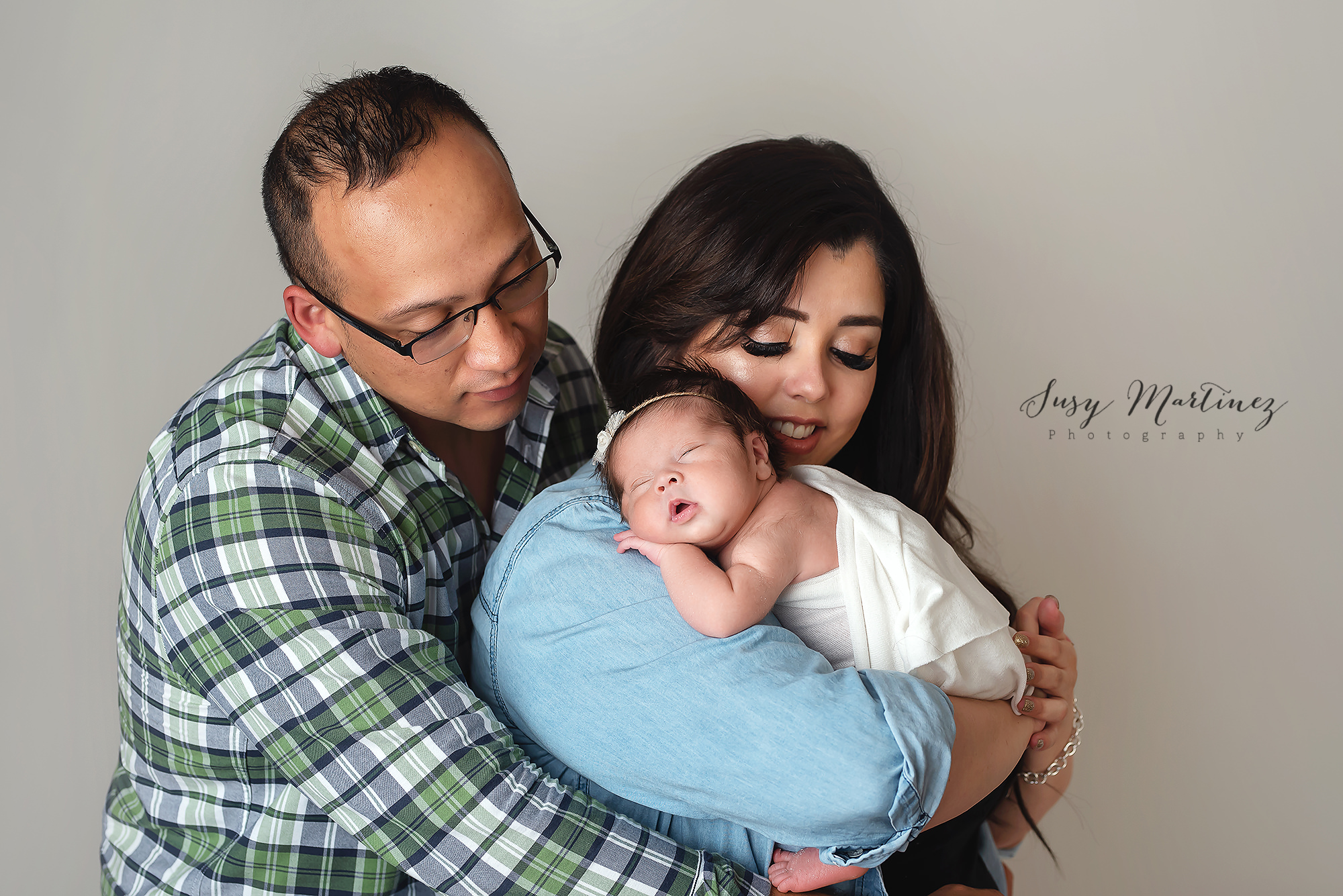 parents hold baby girl during newborn session