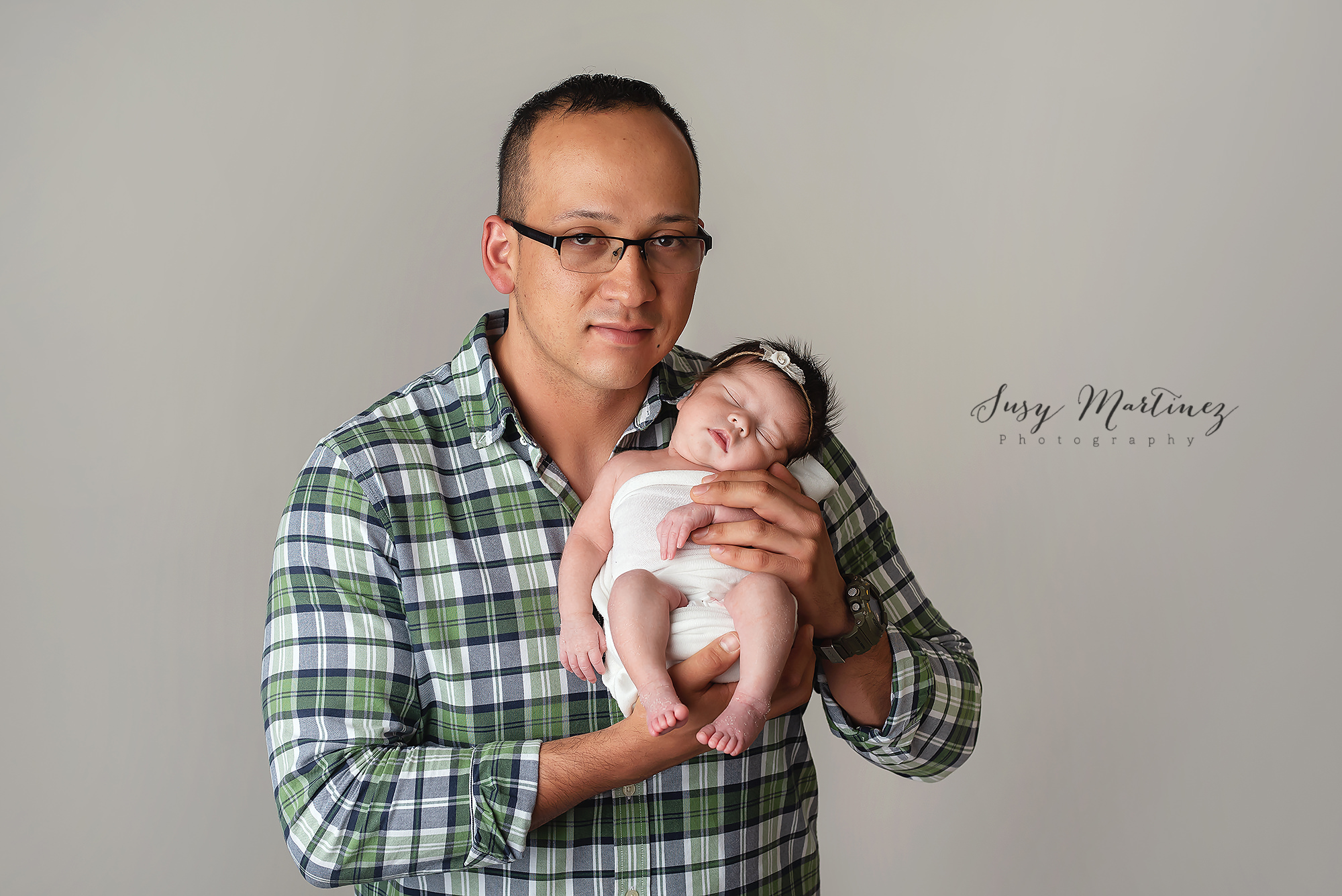 dad holds baby girl during rainbow baby newborn session