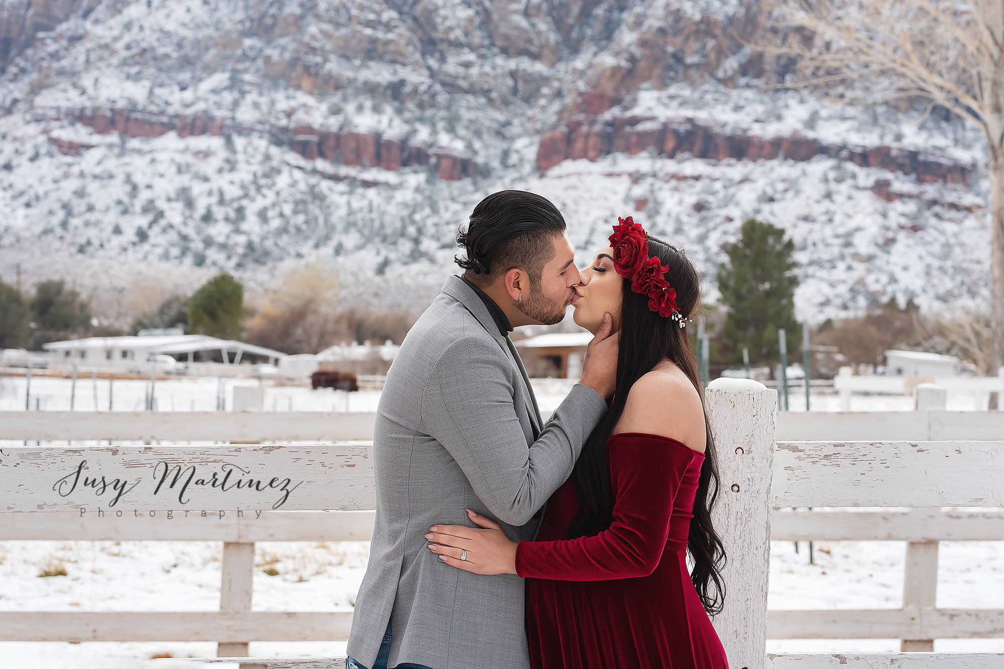 couple kisses during winter maternity portraits in the snow at Spring Mountain Ranch