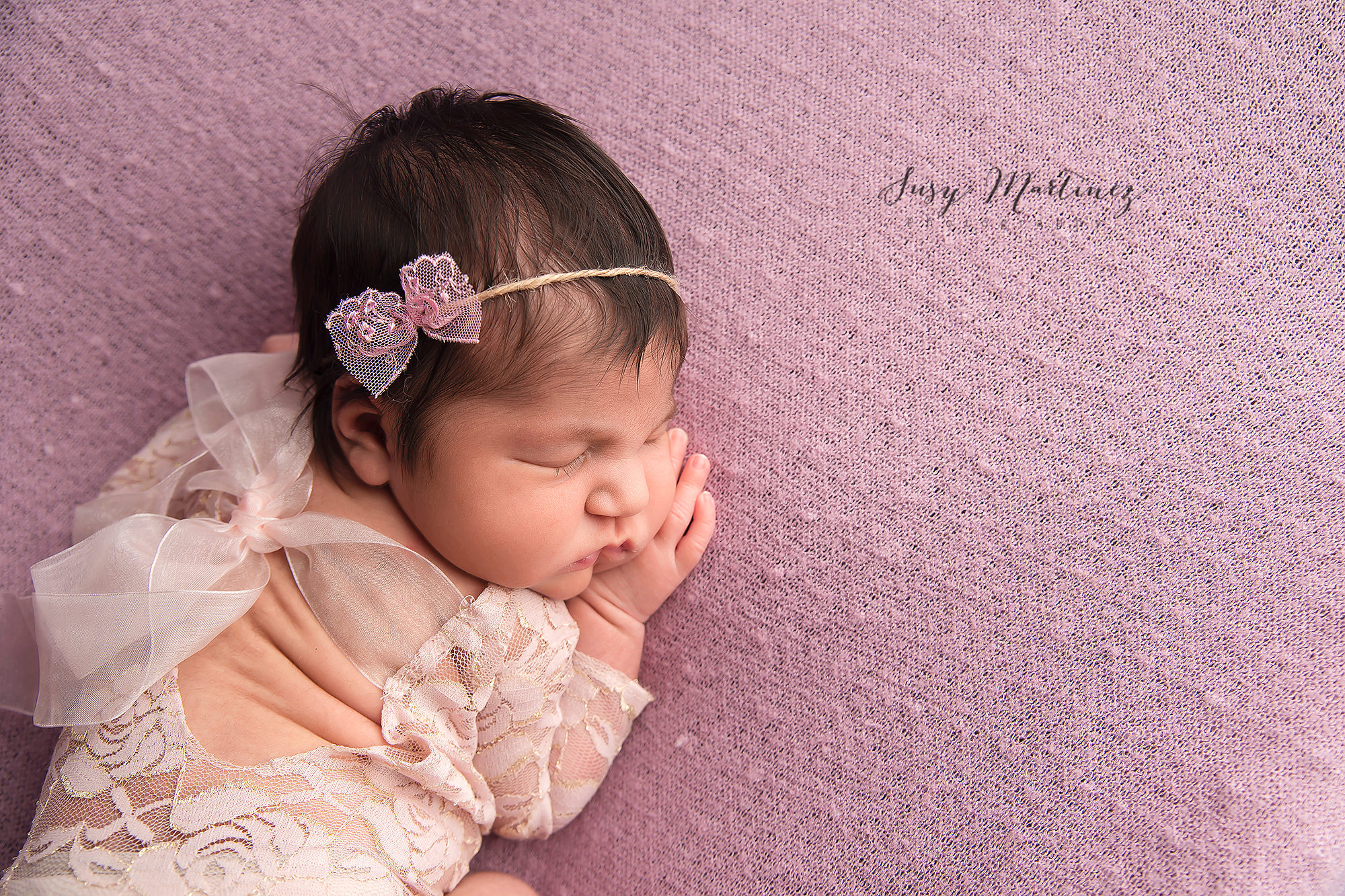 baby sleeps on purple sheet during pastel themed newborn session