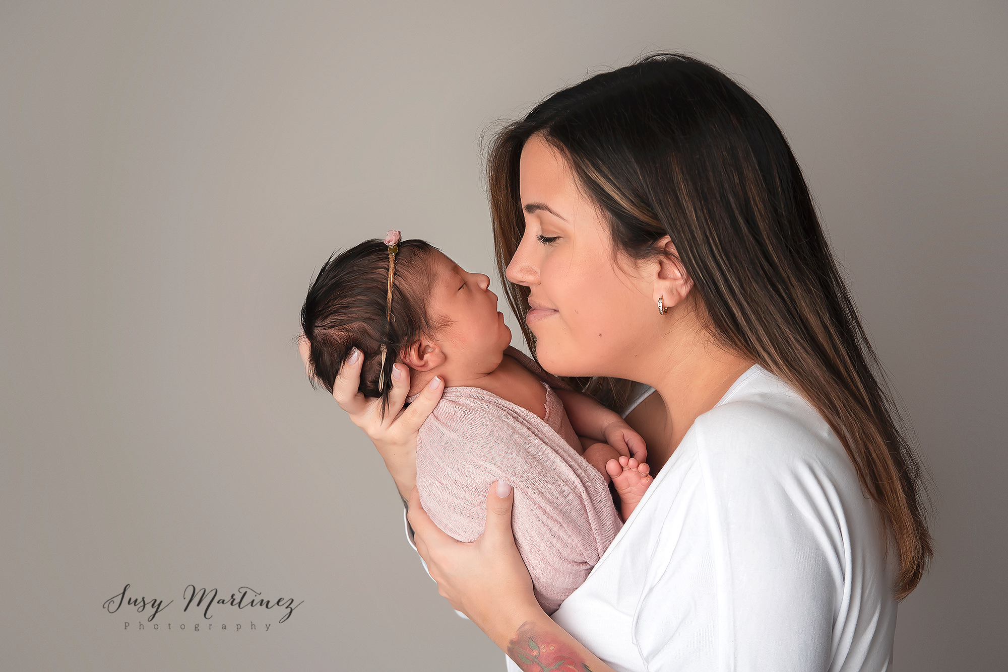 mom snuggles baby girl during pastel themed newborn session