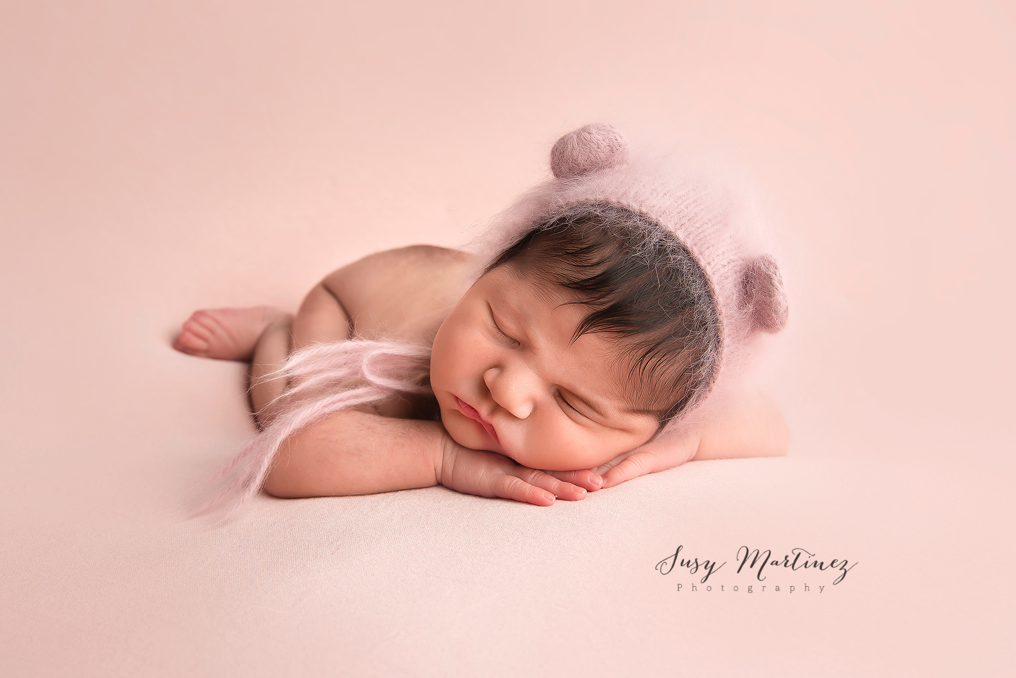 baby sleeps with bear hat during pastel themed newborn session