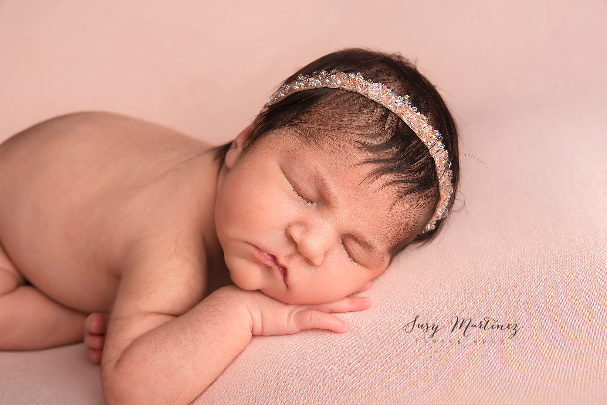 baby girl sleeps with peach headband during Las Vegas newborn session