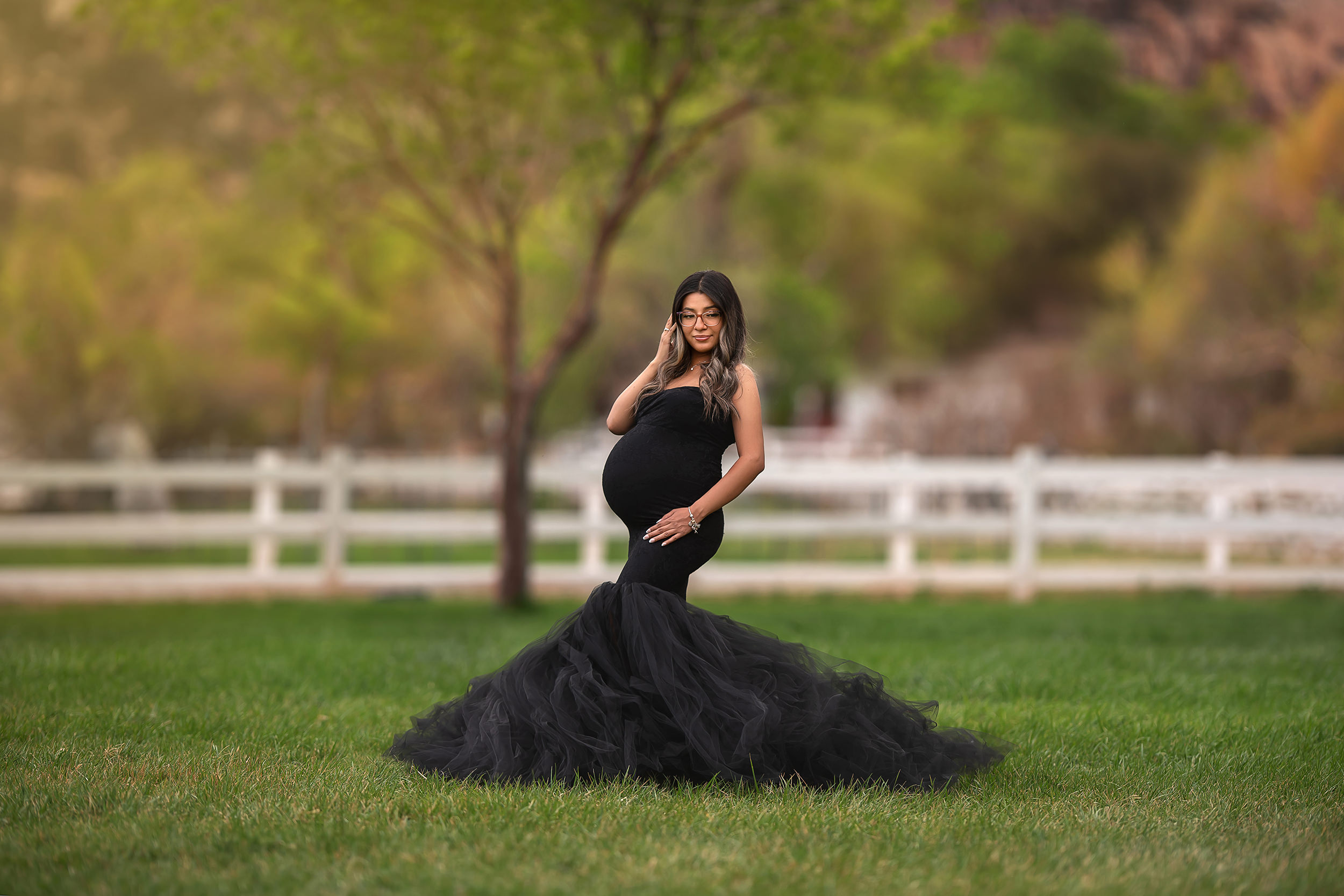 woman stands in black dress during Spring Mountain Ranch Maternity Session