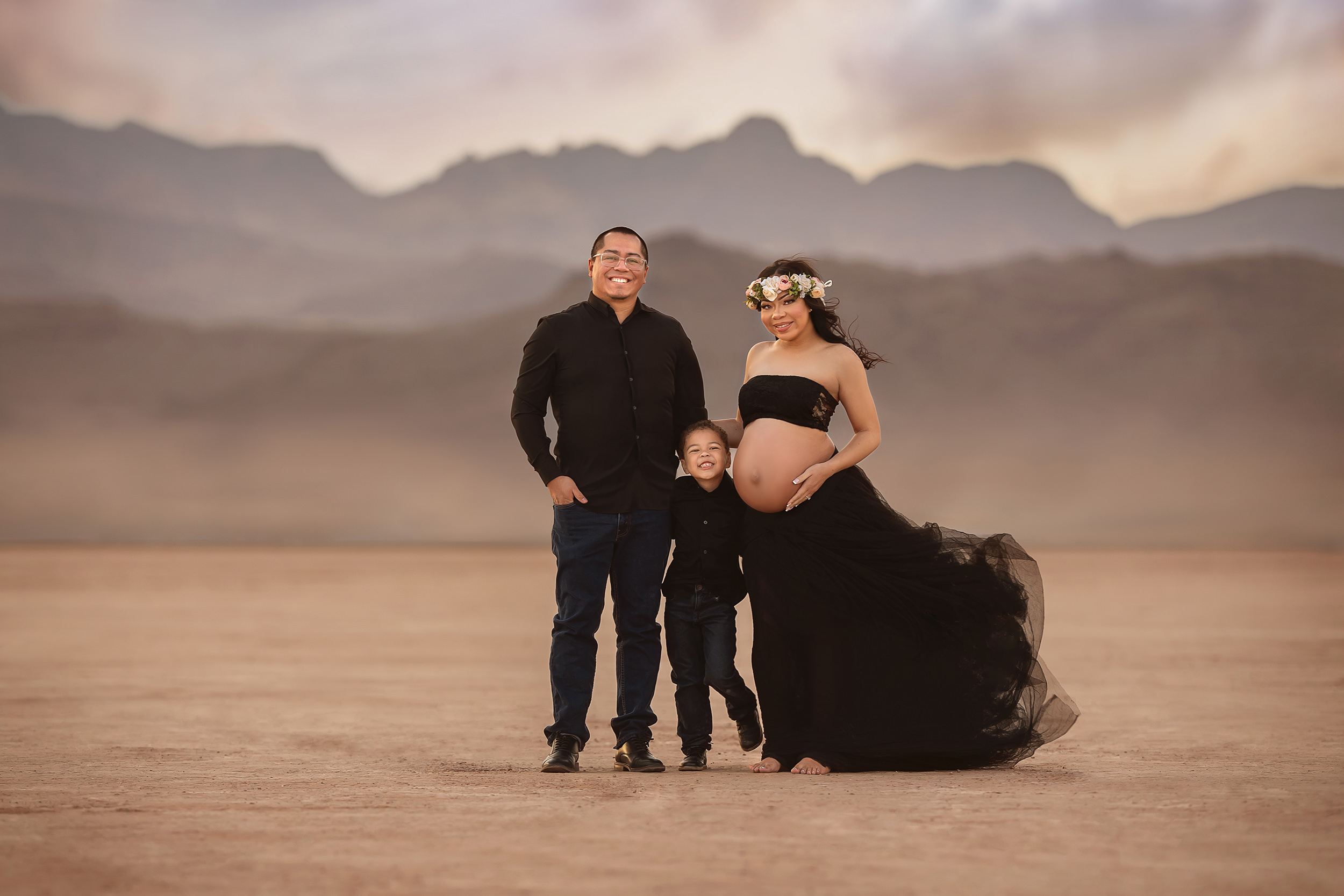family poses other in Dry Lake Bed during mother's maternity portraits 