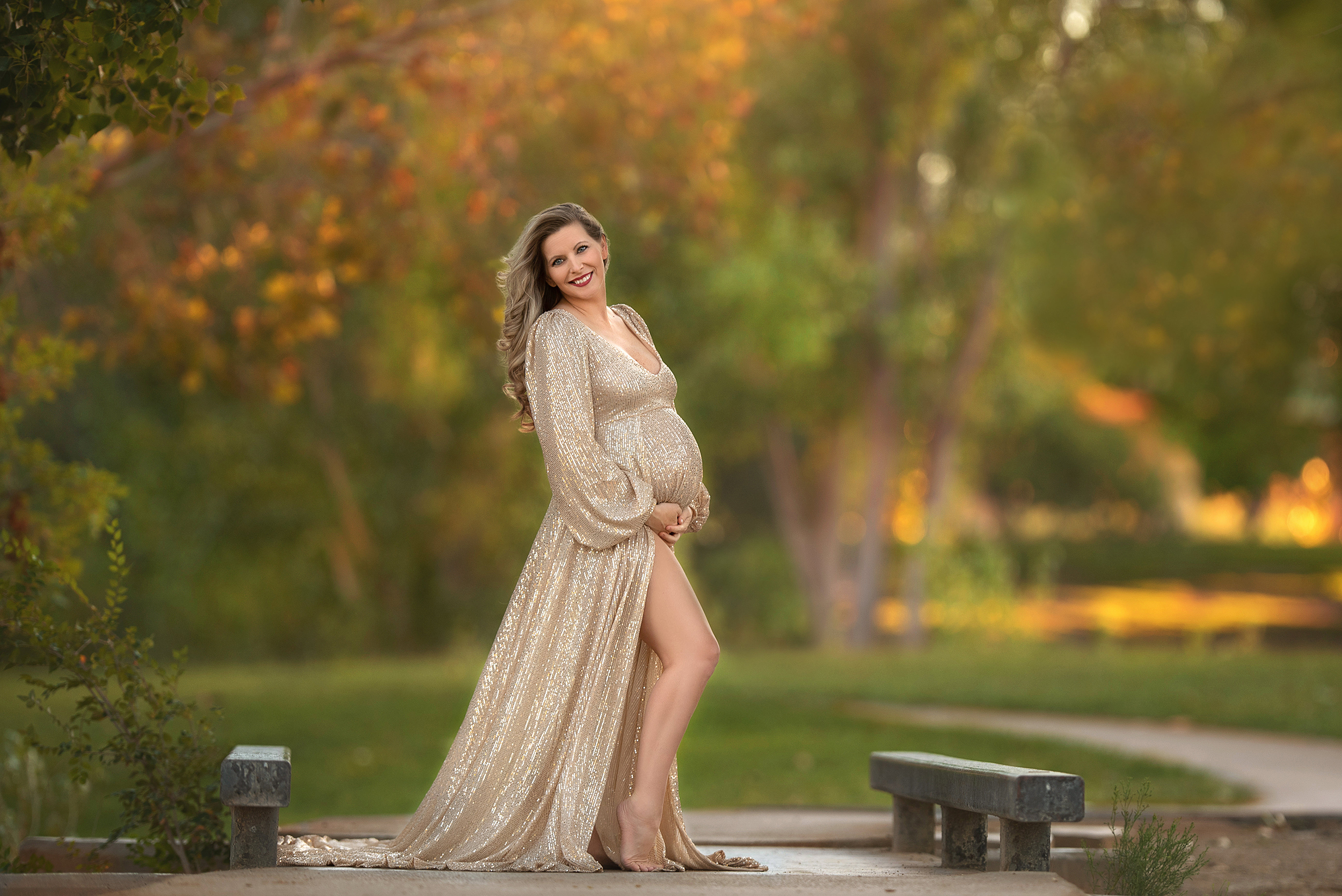 mom holds belly looking over shoulder during Floyd Lamb Park maternity portraits 