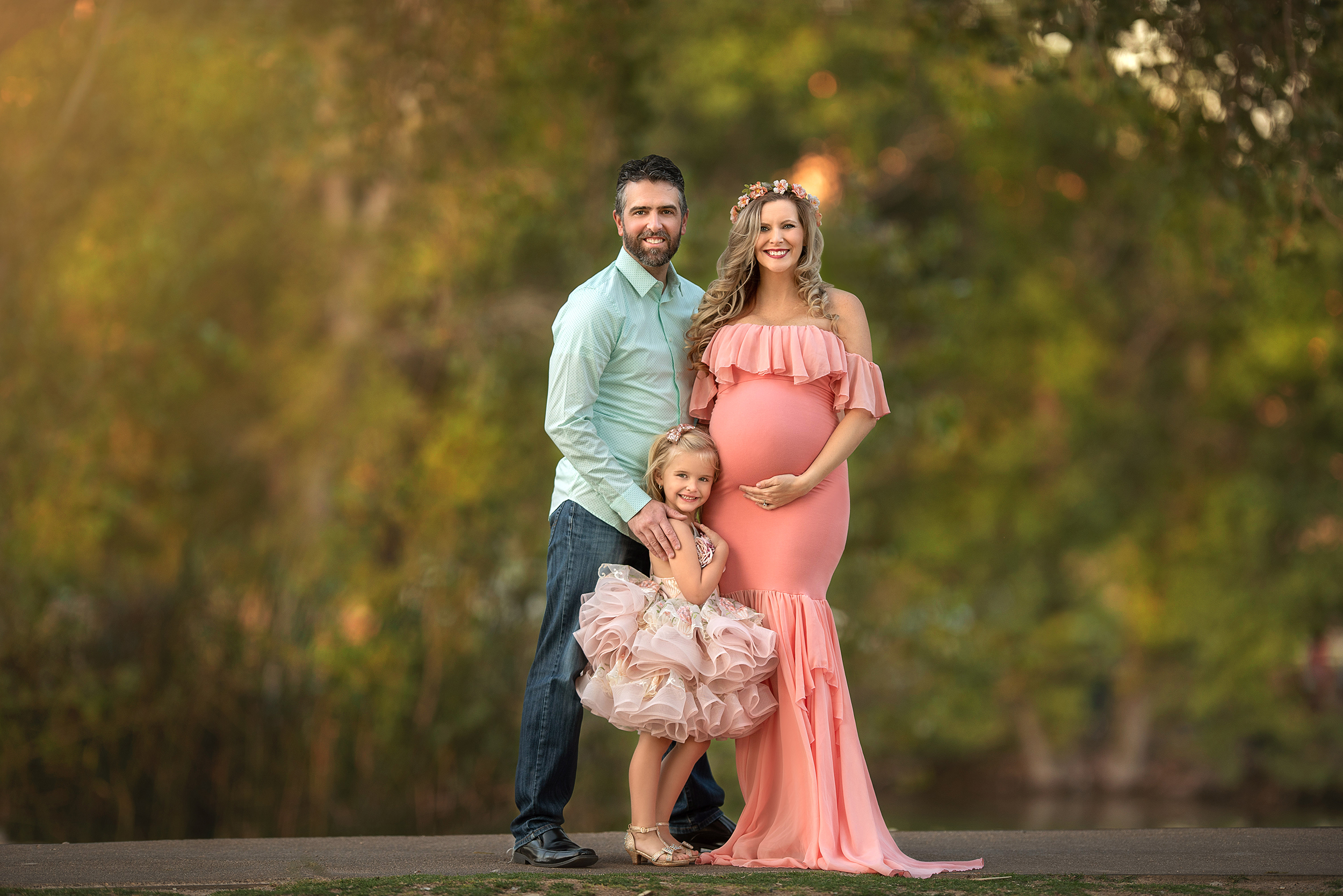 mom stands in peach Sew Trendy Accessories gown holding baby bump during Floyd Lamb Park Maternity Portraits 