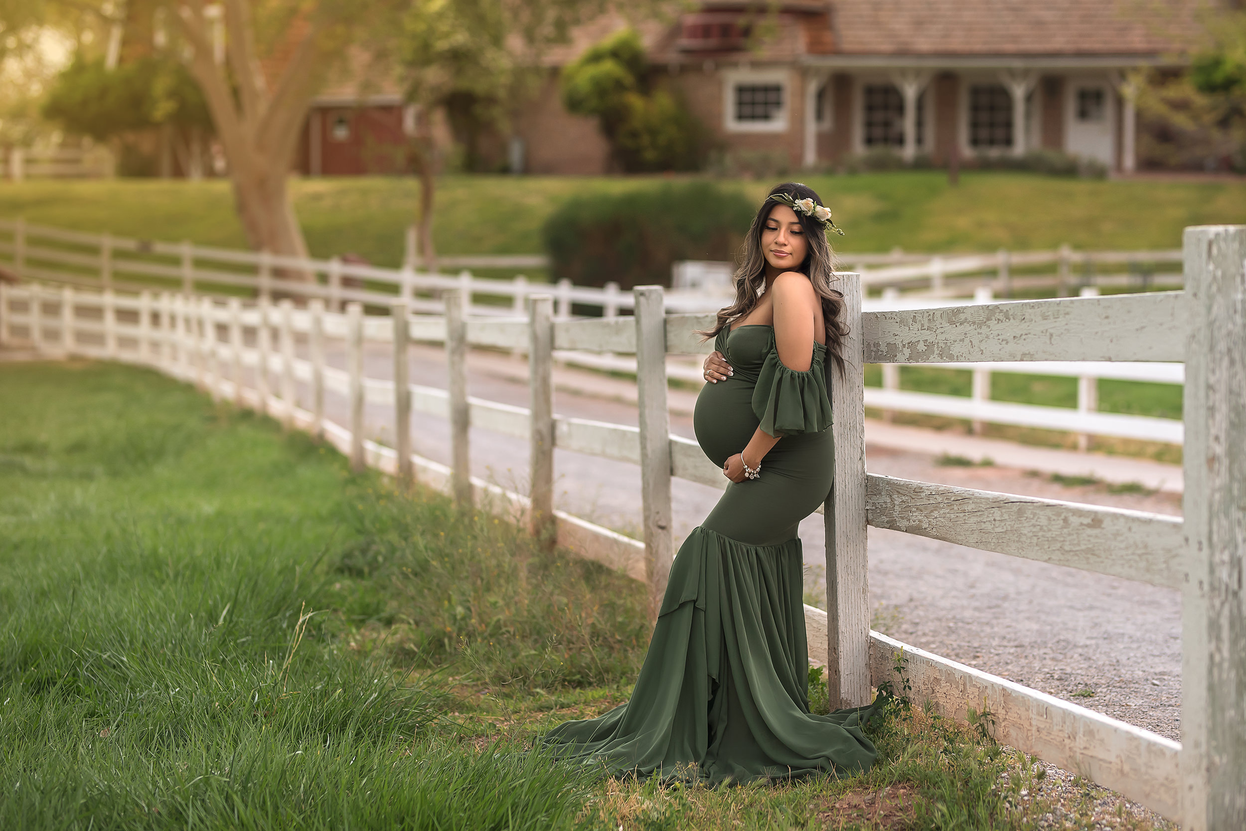 expecting mother leans against white fence during Spring Mountain Ranch Maternity Session