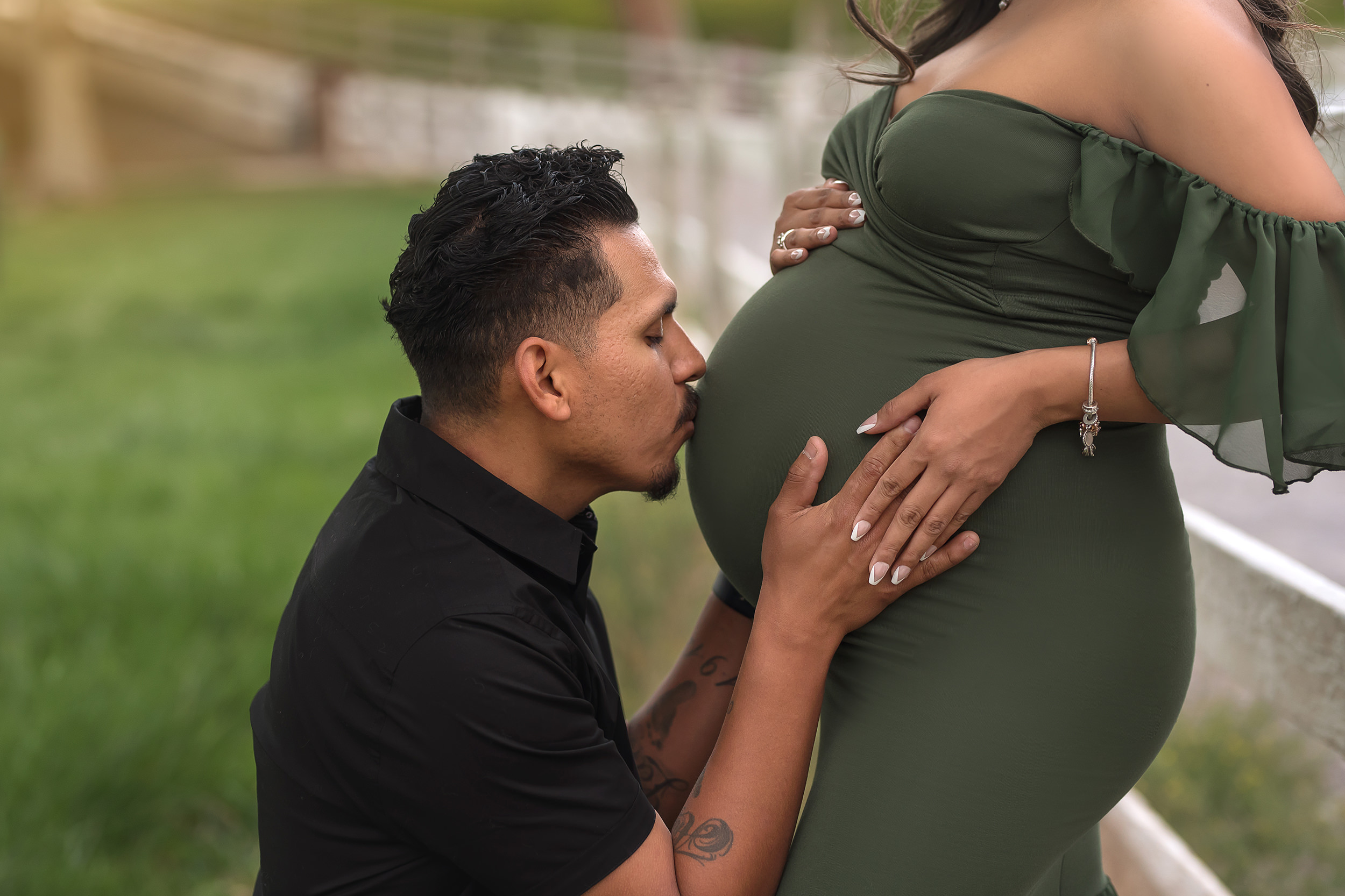 man kisses mom's belly during Spring Mountain Ranch Maternity Session