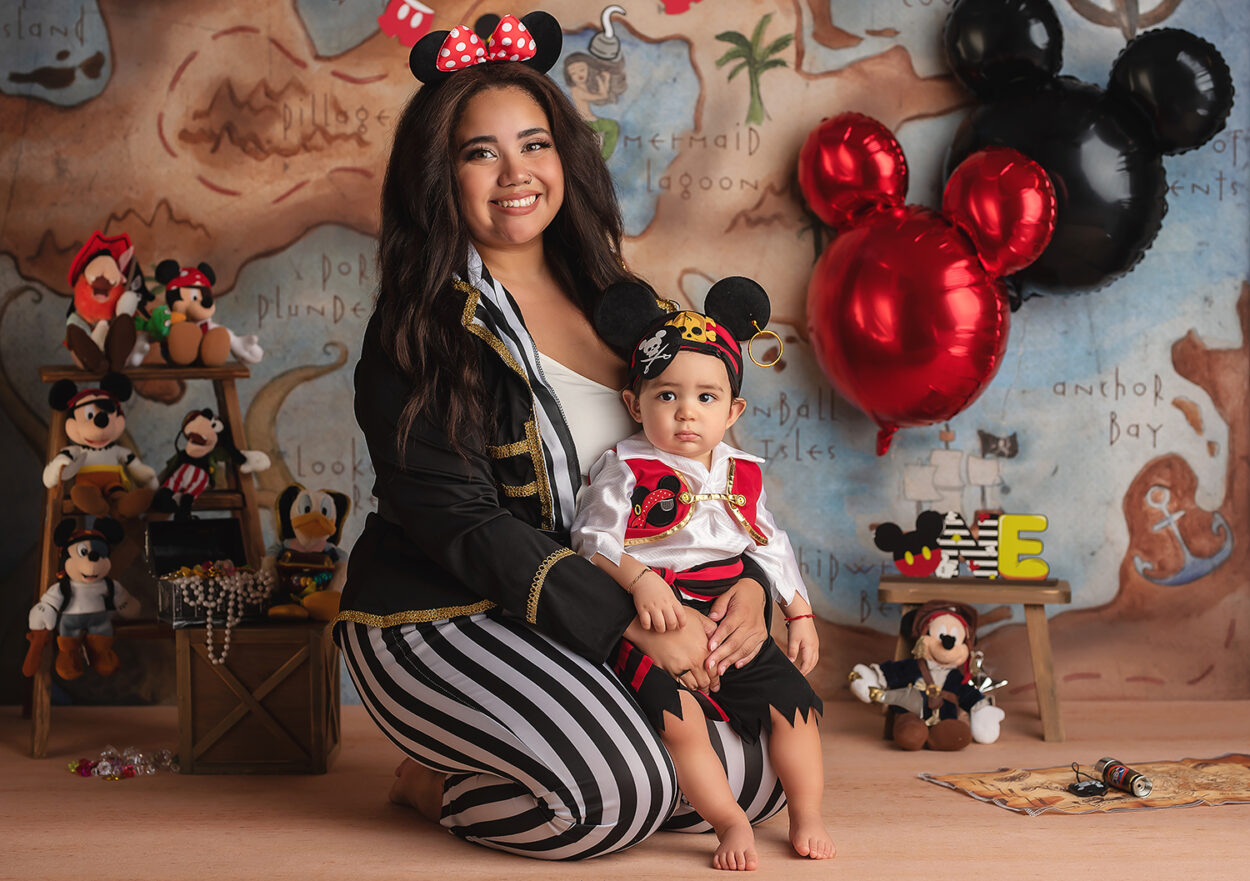 mom in pirate outfit sits with one year old during cake smash with Las Vegas photographer Susy Martinez Photography 