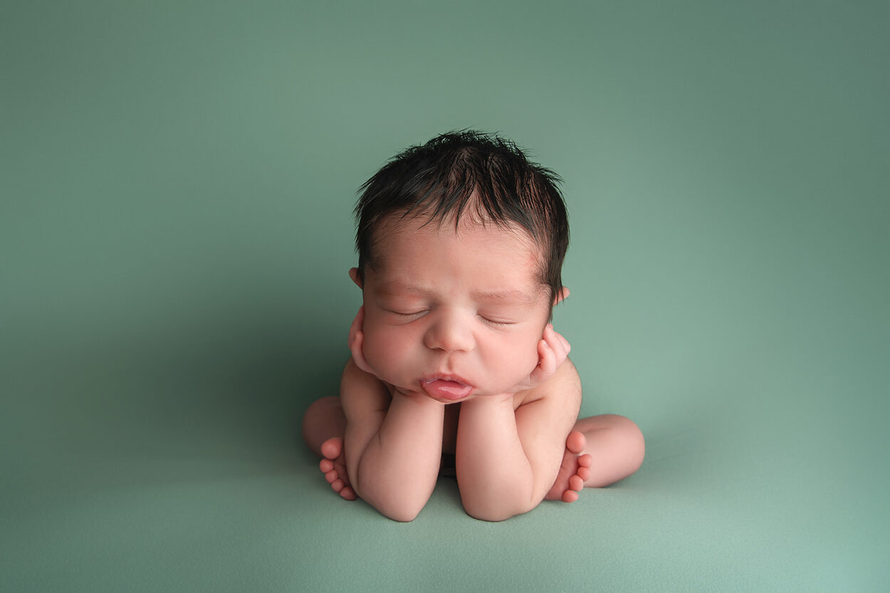 baby boy sleeps in froggy pose during newborn portraits 